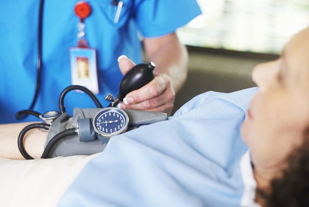 Doktor, hipertansiyonlu hastanın basıncını ölçer